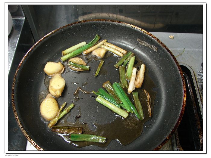 锅中留约一两余油，烧至四成热，改小火下姜片、蒜片、葱段炒出香味  锅灶附近全是油渍：（